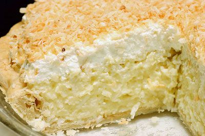 A coconut cream pie with a slice cut out.