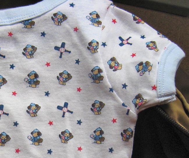 image of a baby onesie with a pictures of puppies playing baseball all over it