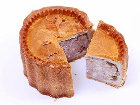A pork pie with a small slice cut out.